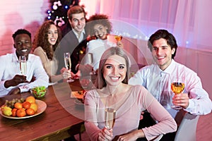 Friends Having Christmas Dinner Holding Glasses Sitting At Table Indoor