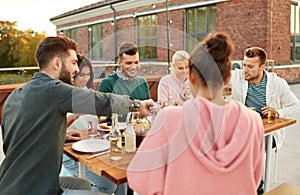 Friends having dinner or rooftop party in summer