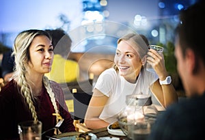 Friends having a dinner together at a rooftop bar