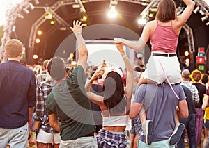 Friends having fun in the crowd at music festival, back view photo