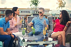 Friends having fun and drinking cocktails outdoor