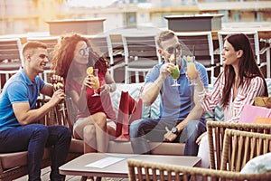 Friends drinking cocktails outdoor on a penthouse balcony