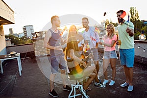 Friends having fun and drinking cocktails outdoor on a rooftop get together