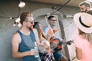 Friends having fun and drinking cocktails outdoor on a rooftop get together