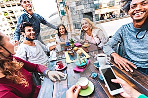 Friends having fun drinking at coffeehouse - Multiracial people talking together at restaurant reopening - New normal lifestyle