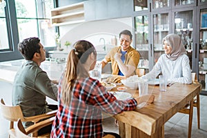 friends having fun eating lunch together at home with traditional food