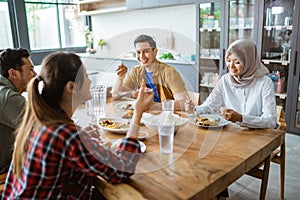 friends having fun eating lunch together at home with traditional food