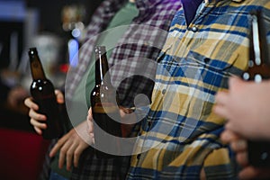 Friends having fun. Happy young men in casual wear drinking beer in pub.