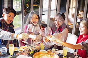 Friends having fun in hot pot restaurant