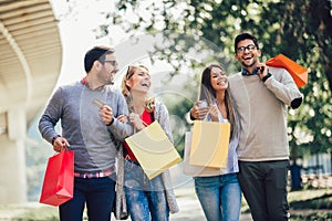 Friends having fun in shopping holding shopping bags and credit card