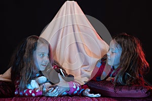 Friends having fun with teddy bears in blanket tent