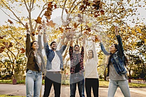 Friends having fun throwing leaves in the air