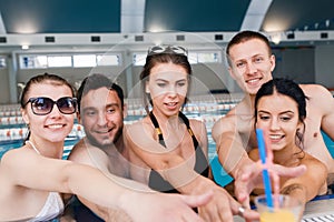 Friends having party and drinking buckets at a swimming pool