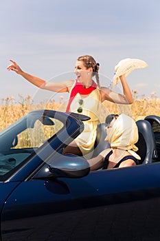 Friends having summer joyride in convertible car