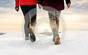 Friends hiking on the mountaintop covered with snow