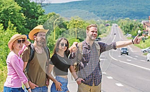 Friends hitchhikers looking for transportation sunny day. Family weekend. Company friends travelers hitchhiking at edge