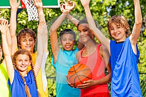 Friends hold arms up at basketball game