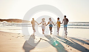 Friends, holding hands and running at sunset on beach in summer or walking together on holiday in California with