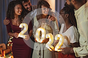 Friends holding numbers 2022 for New Years midnight countdown