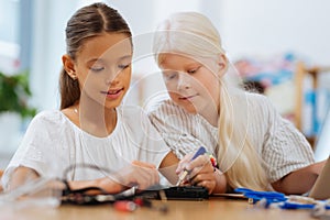 Friends inventing a device together in a classroom