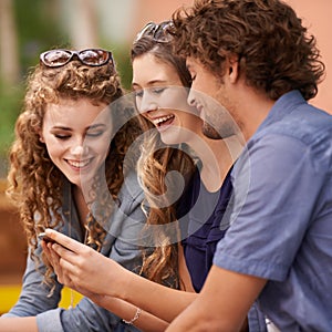 Friends, laughing and talking with cellphone for social media, internet and text. Young people, conversation and humor