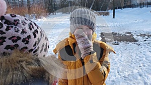 Friends lively communicate in the winter on the street. The girls are dressed in winter clothes. There is snow all