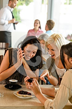 Friends looking at photographs and laughing cafe