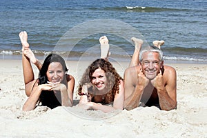 Friends lying on sandy beach