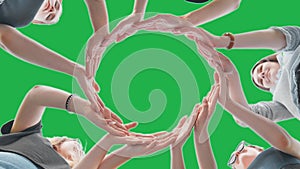 Friends make a circle with their palms against a green background.