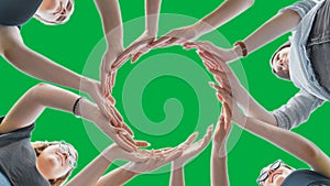 Friends make a circle with their palms against a green background.