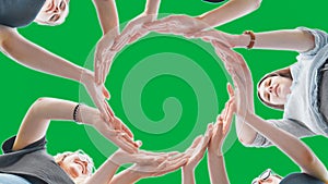 Friends make a circle with their palms on a green background.