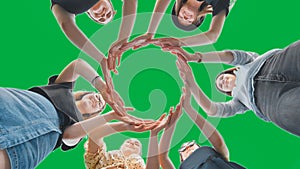 Friends make a circle with their palms on a green background.