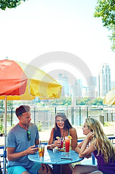 Friends make summer fun. three young friends sitting at an outdoor cafe.