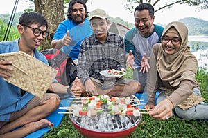 Friends making a barbecue together outdoors