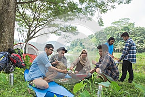 Friends making a barbecue together outdoors