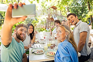 Friends making selfie photo in outdoor restaurant