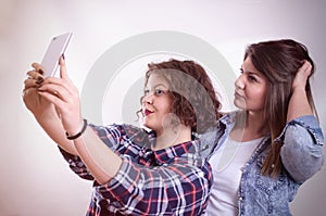 Friends making selfie. Two beautiful young women making selfie