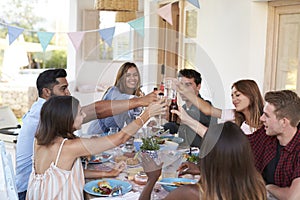 Friends making a toast at a dinner party on a patio, Ibiza