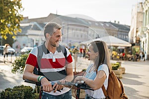 Friends meet while riding electric scooters and have happy conversation