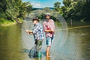 Friends men with fishing rod and net. Set up rod with hook line sinker. Legend has retired. Two male friends dressed in