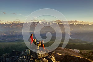 Friends on mountain top looking to sunset