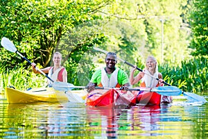 Friends paddling with canoe on river