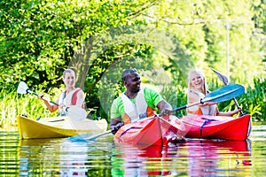 Friends paddling with canoe on river