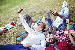 Friends in the park having fun and making a group selfie