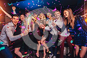 Friends partying in a nightclub and toasting drinks photo