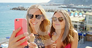 Friends, phone and selfie with ice cream, happy and humour while taking picture on travel, trip and summer vacation