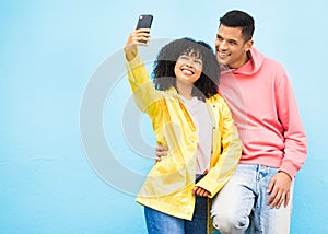 Friends, phone and smile for selfie on a blue background for fashion, style or friendship together. Young man and woman