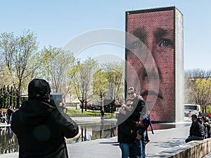 Friends photograph each other in front of Crown Fountain, Chicago