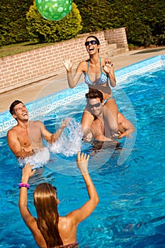 Friends playing ball in water laughing
