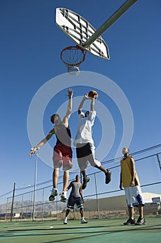 Friends Playing Basketball Against Blue Sky